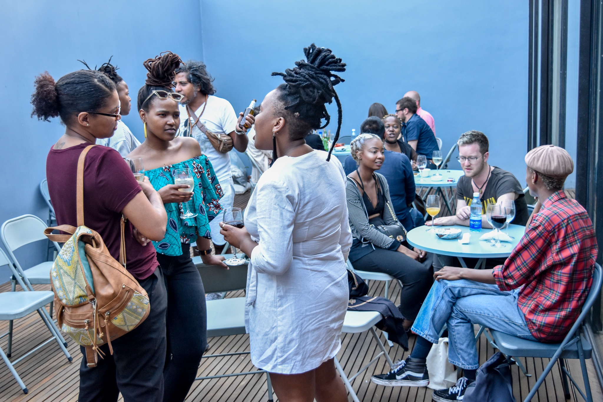 Event photograph from the ‘Sikkum/Sikum’ event on A4’s top floor that shows attendees seated and standing in conversation in the deck area.
