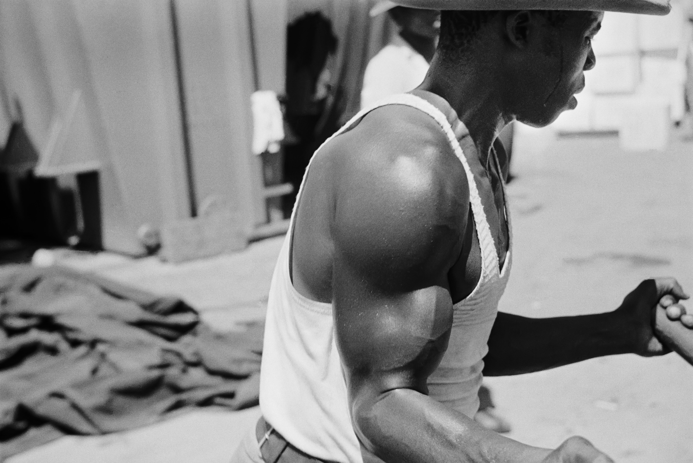 David Goldblatt's black-and-white photograph 'Stevedore, Durban' shows a man to the right of the frame, holding someone's hand. 
