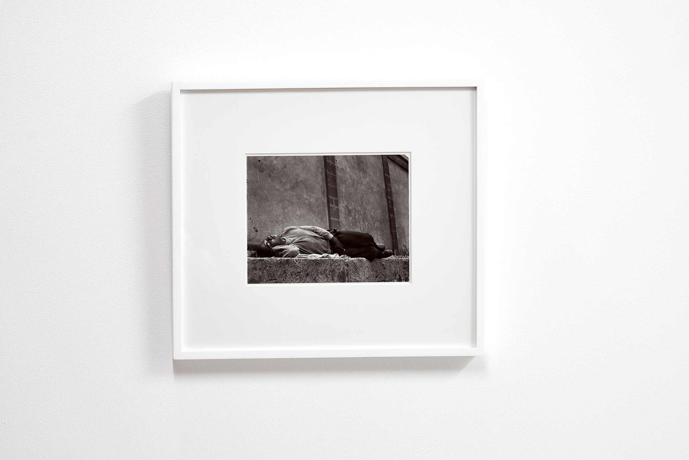 Installation photograph that shows Manuel Álvarez Bravo’s framed monochrome photograph 'El Soñador’ mounted on a white wall.
