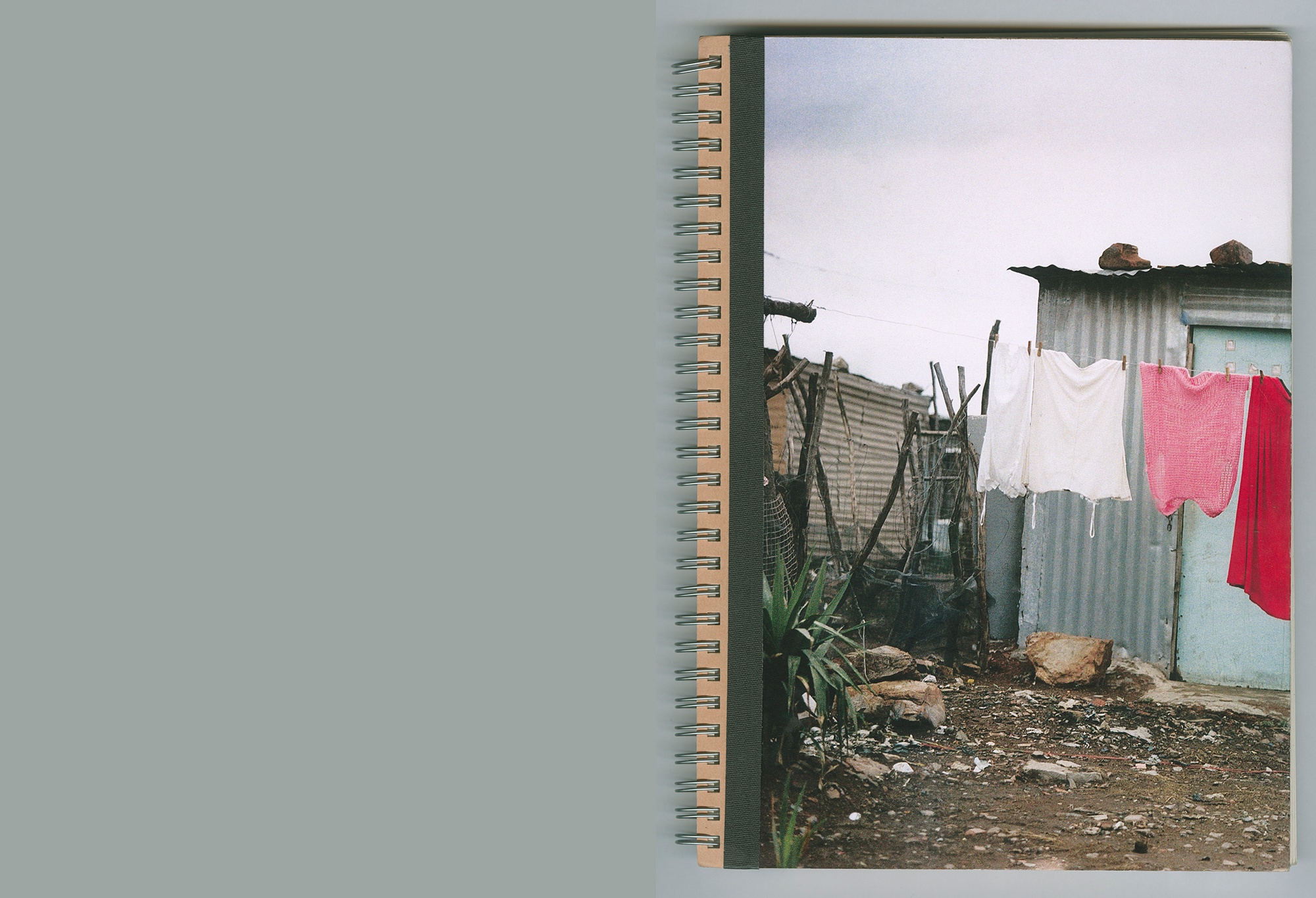 A still frame from Lindokuhle Sobekwa's video presentation 'I carry Her photo with Me' shows a topdown view of the cover of a ring-bound volume.
