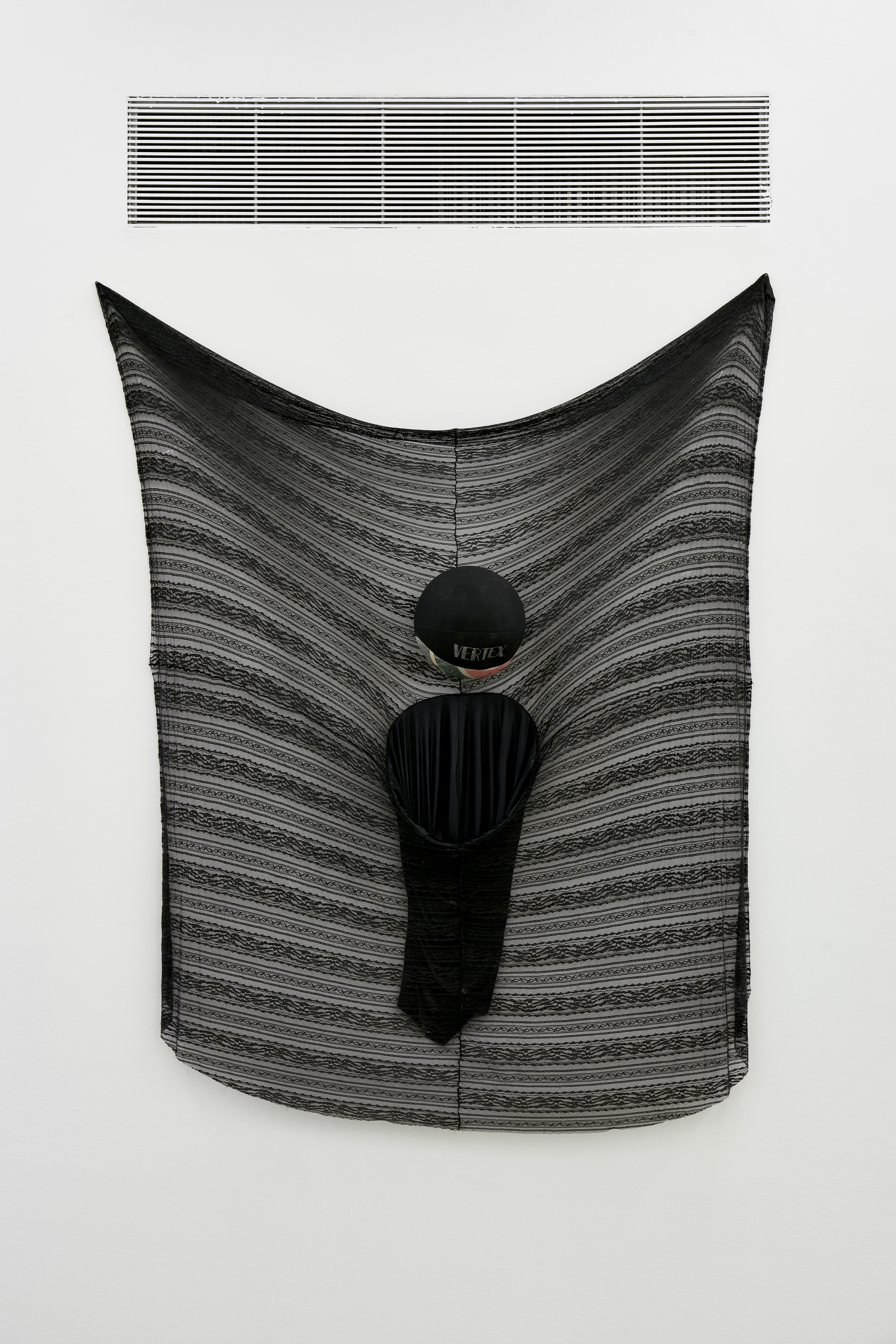 A photograph of Kevin Beasley's mixed media work 'Vertex' mounted on a white wall.
