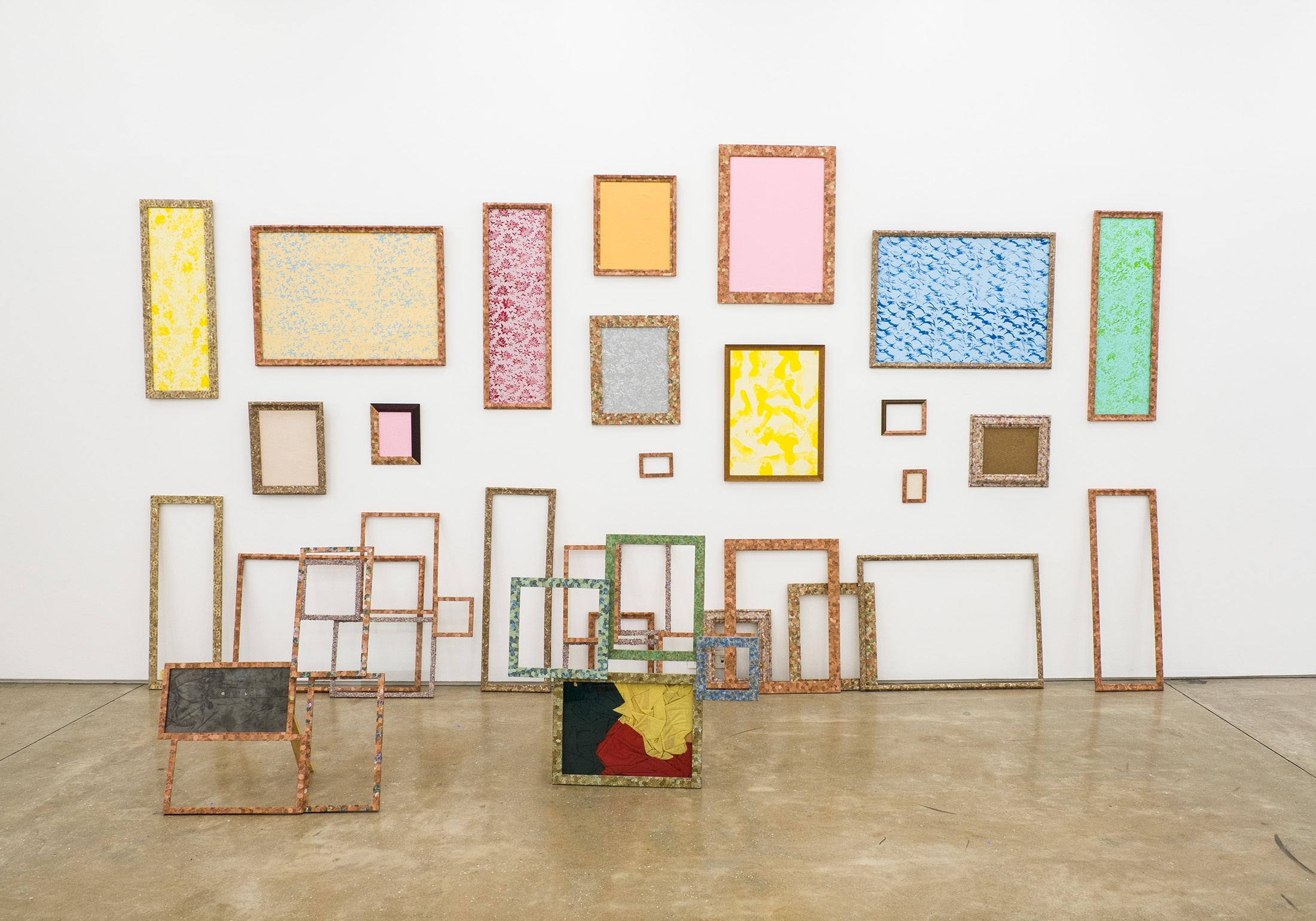 A photograph of Meschac Gaba's installation 'Colour of Cotonou'. The installation consists of found objects, Beninese bank notes, wooden frames and glass.
